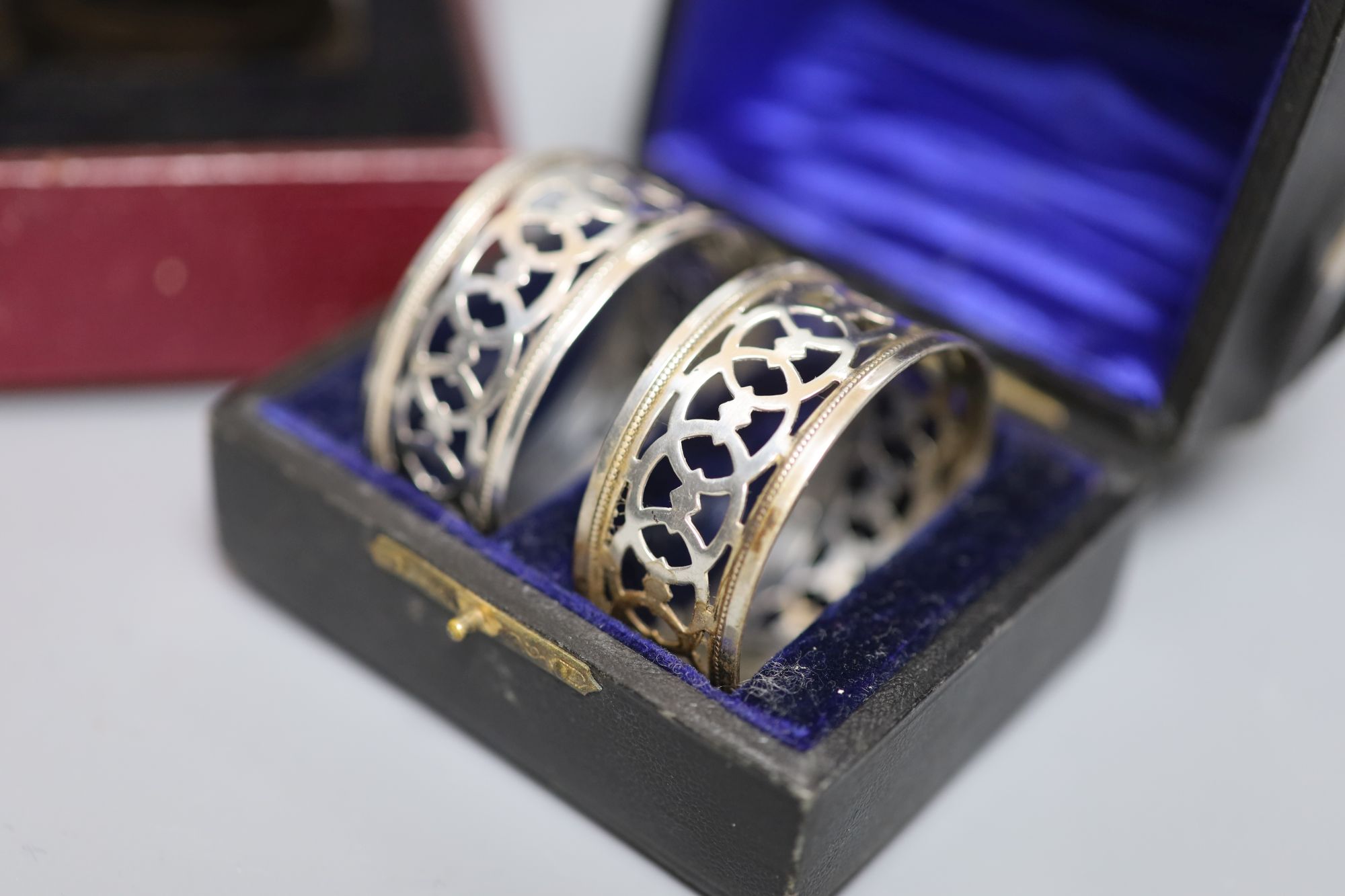 Three cased pairs of Edwardian and later silver napkin rings.